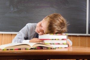 Sleeping boy with books at the desk